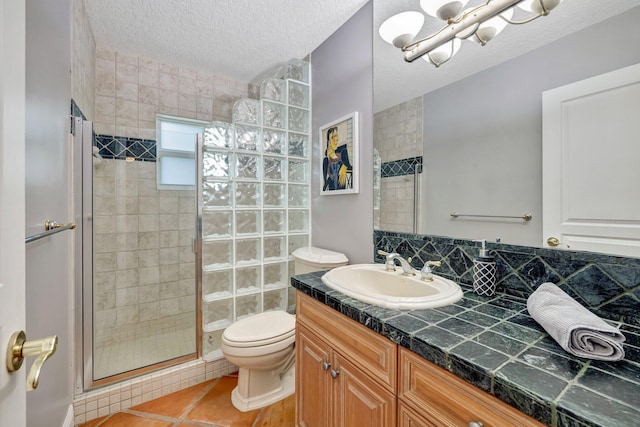 bathroom featuring vanity, a textured ceiling, tile patterned flooring, toilet, and a shower with shower door