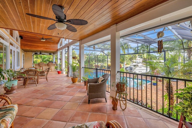 sunroom featuring ceiling fan and wooden ceiling