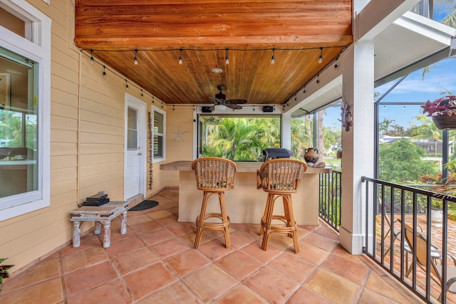 sunroom / solarium with ceiling fan and wood ceiling