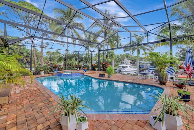 view of swimming pool featuring glass enclosure, a patio area, and an in ground hot tub