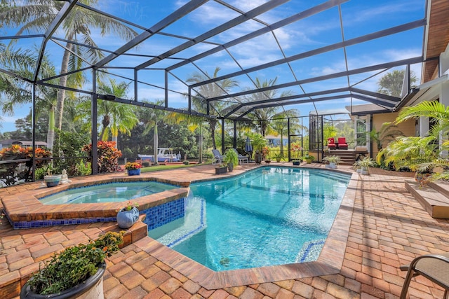 view of pool featuring glass enclosure, a patio area, and an in ground hot tub