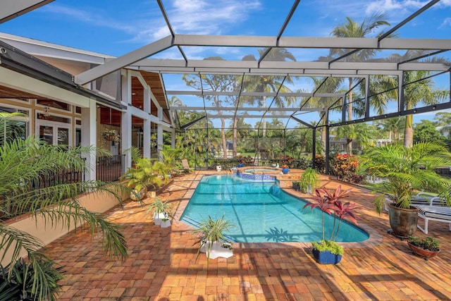 view of swimming pool featuring a lanai, an in ground hot tub, and a patio