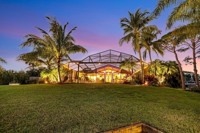 yard at dusk featuring a lanai