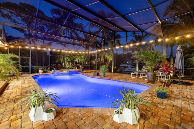 view of swimming pool with glass enclosure and a patio area