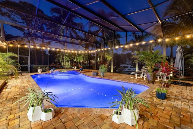 view of swimming pool featuring an in ground hot tub, a patio area, and a lanai