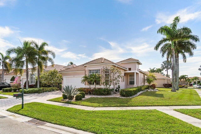 mediterranean / spanish house featuring a front yard and a garage