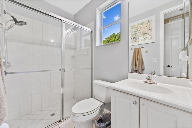 bathroom with a shower with door, vanity, and toilet