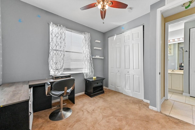 carpeted office featuring ceiling fan