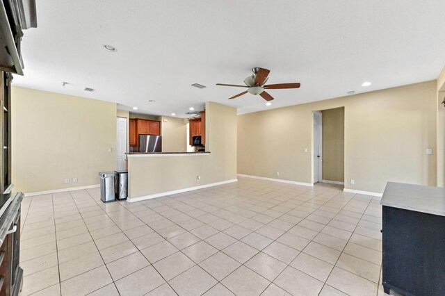 unfurnished living room with ceiling fan and light tile patterned flooring