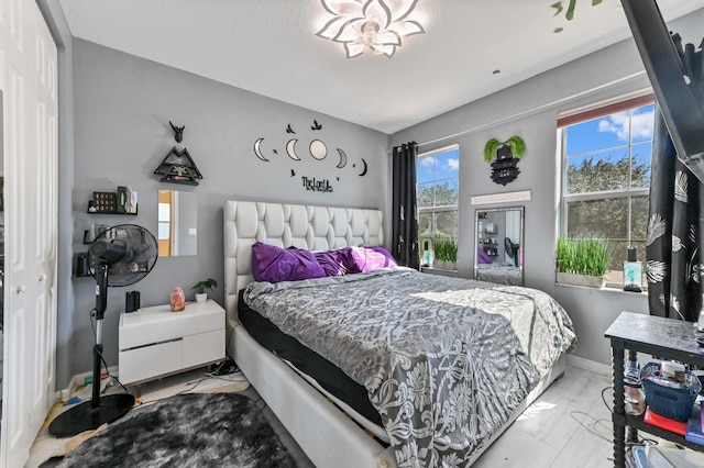 bedroom with a closet, a textured ceiling, and multiple windows