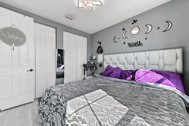 bedroom with a textured ceiling and two closets