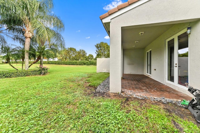 view of yard with french doors and a patio