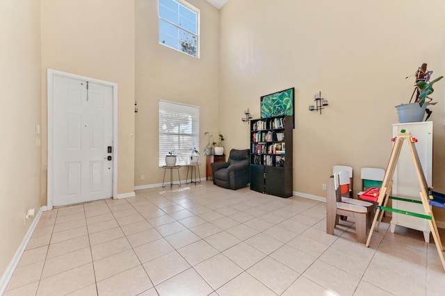 foyer featuring light tile patterned floors and a towering ceiling