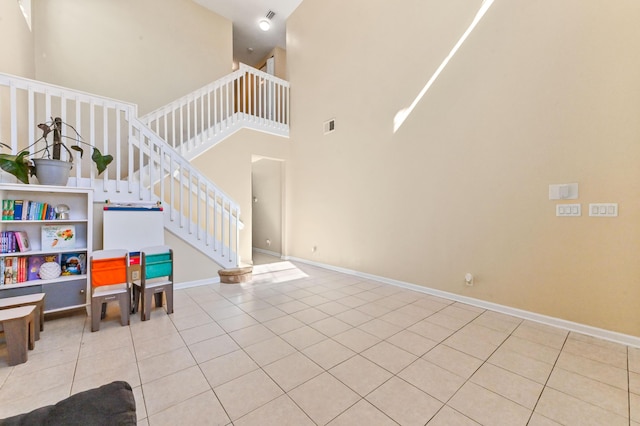 interior space with a towering ceiling and light tile patterned flooring