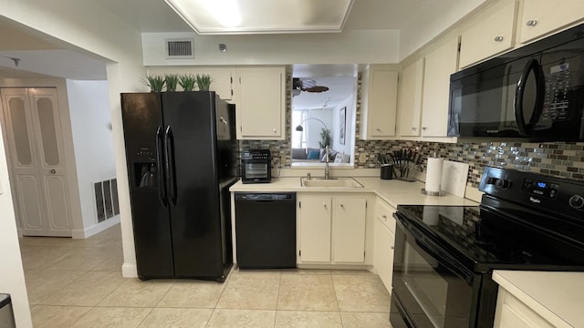 kitchen with light tile patterned flooring, decorative backsplash, sink, and black appliances