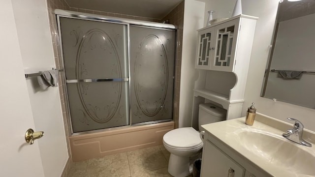 full bathroom with combined bath / shower with glass door, tile patterned floors, vanity, and toilet