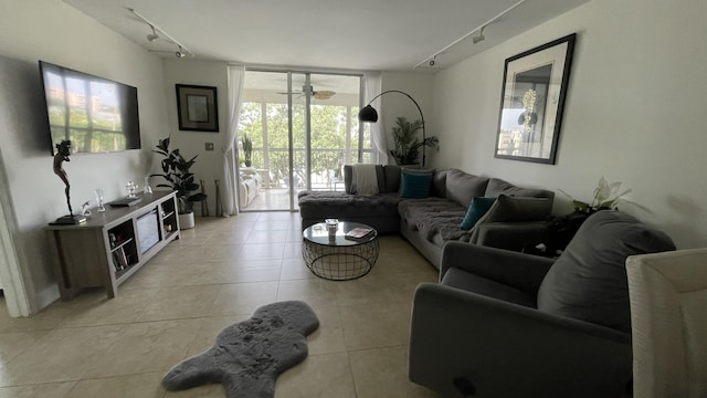 tiled living room with ceiling fan, floor to ceiling windows, and rail lighting