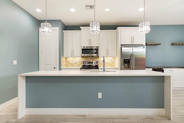 kitchen featuring sink, white cabinets, a large island, and stainless steel appliances