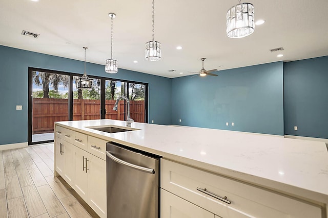 kitchen featuring sink, stainless steel dishwasher, light stone countertops, and hanging light fixtures