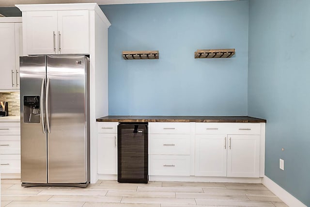 kitchen featuring wine cooler, white cabinets, light wood-type flooring, stainless steel fridge with ice dispenser, and decorative backsplash