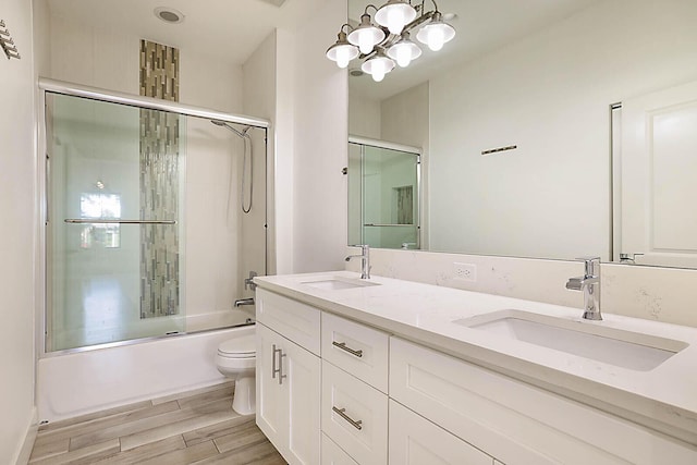 full bathroom featuring combined bath / shower with glass door, hardwood / wood-style flooring, toilet, and vanity