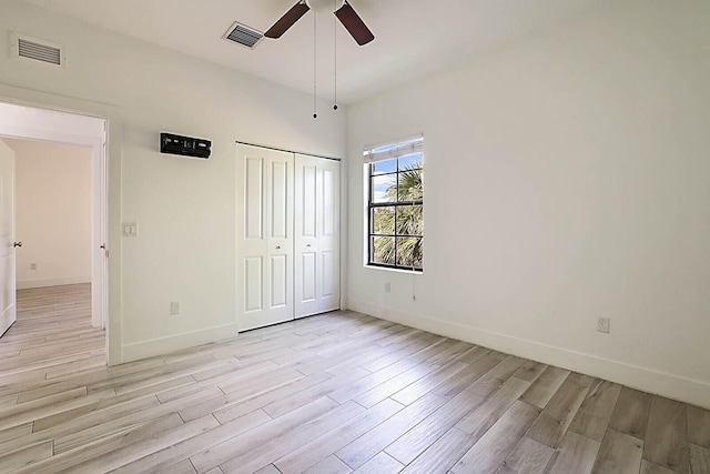 unfurnished bedroom featuring ceiling fan, a closet, and light wood-type flooring