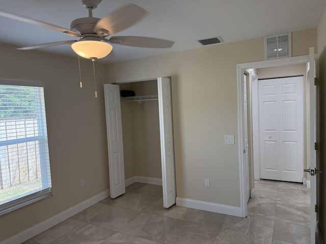 unfurnished bedroom featuring a closet, ceiling fan, and light tile patterned flooring