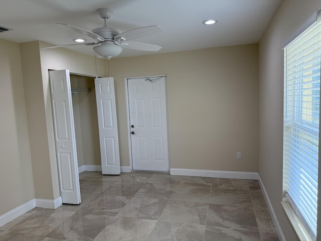 unfurnished bedroom with ceiling fan and a closet