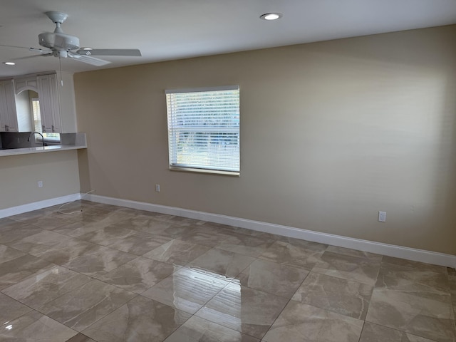 unfurnished room with ceiling fan and sink