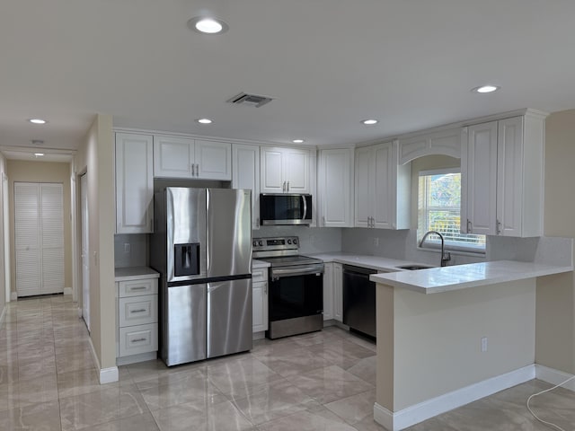 kitchen featuring backsplash, stainless steel appliances, and white cabinetry