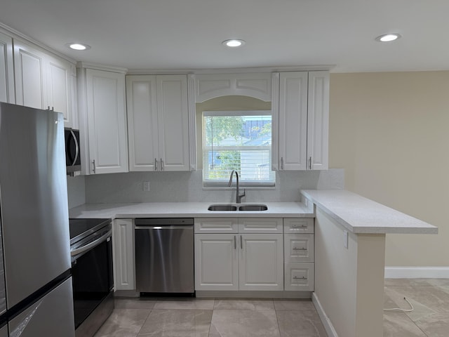 kitchen with tasteful backsplash, white cabinetry, sink, and stainless steel appliances