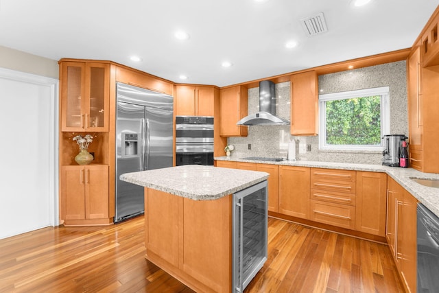 kitchen featuring light hardwood / wood-style flooring, stainless steel appliances, wine cooler, and wall chimney range hood