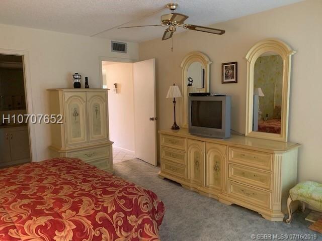 carpeted bedroom featuring ceiling fan and a textured ceiling