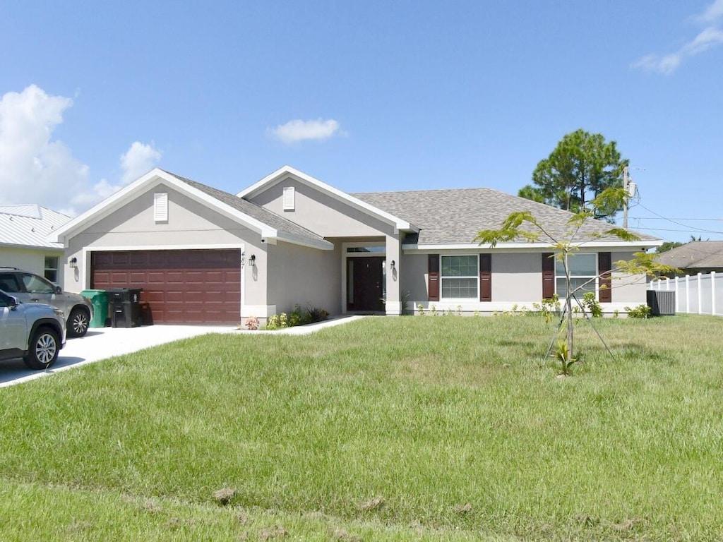 view of front of property featuring a front yard and a garage