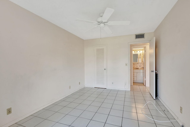 tiled spare room featuring ceiling fan