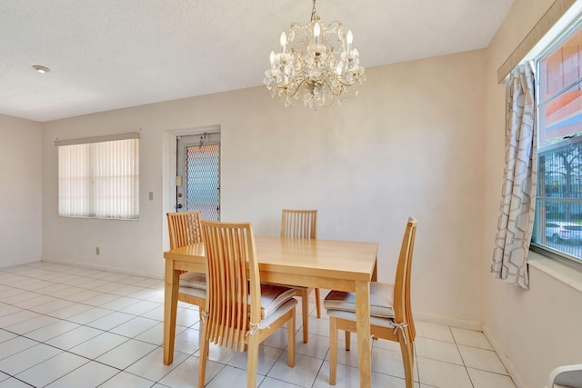 tiled dining space featuring a wealth of natural light, a textured ceiling, and a notable chandelier