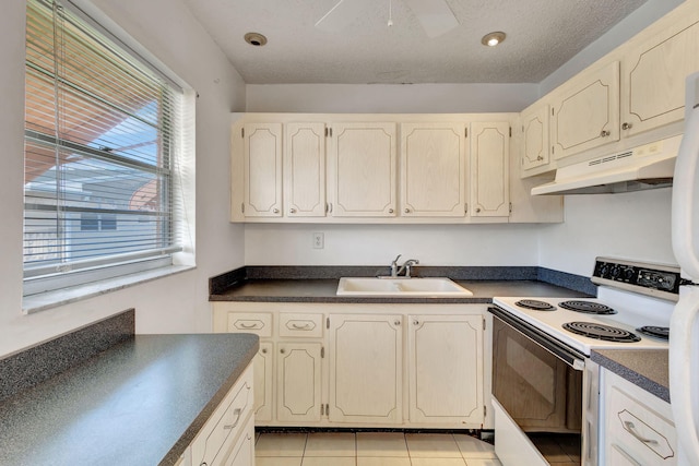 kitchen with light tile patterned flooring, a textured ceiling, white range with electric stovetop, and sink