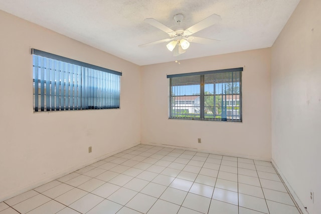 tiled empty room featuring ceiling fan