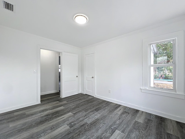 unfurnished room featuring crown molding and dark wood-type flooring