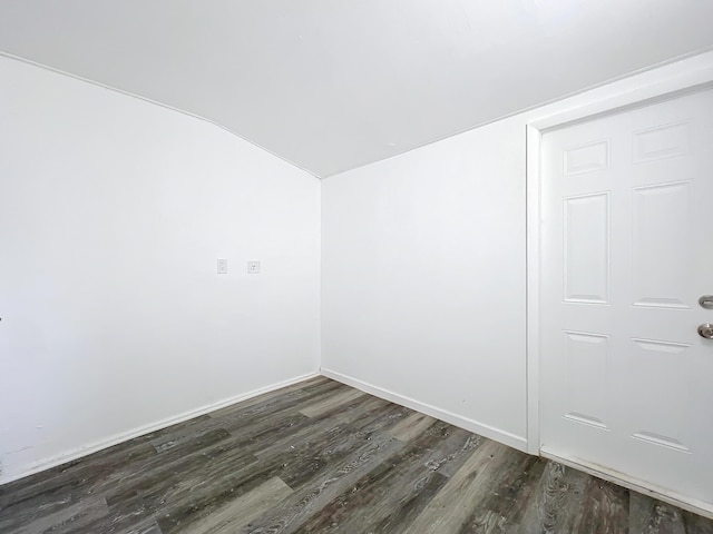 spare room with dark hardwood / wood-style floors and vaulted ceiling