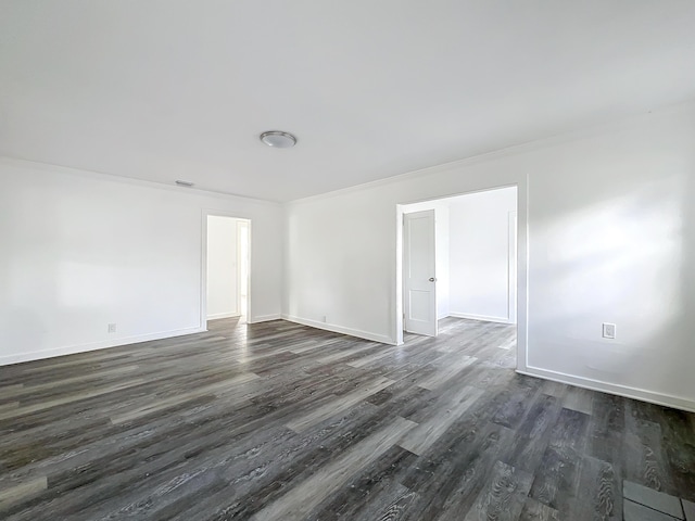 unfurnished room with ornamental molding and dark wood-type flooring