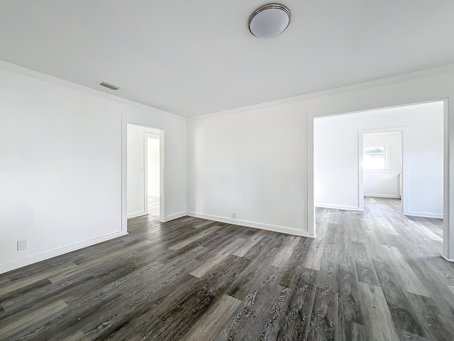 empty room featuring dark hardwood / wood-style flooring and ornamental molding