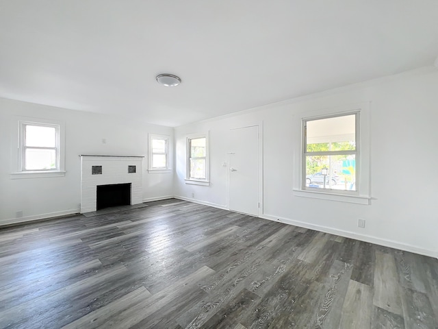 unfurnished living room featuring a fireplace and dark wood-type flooring