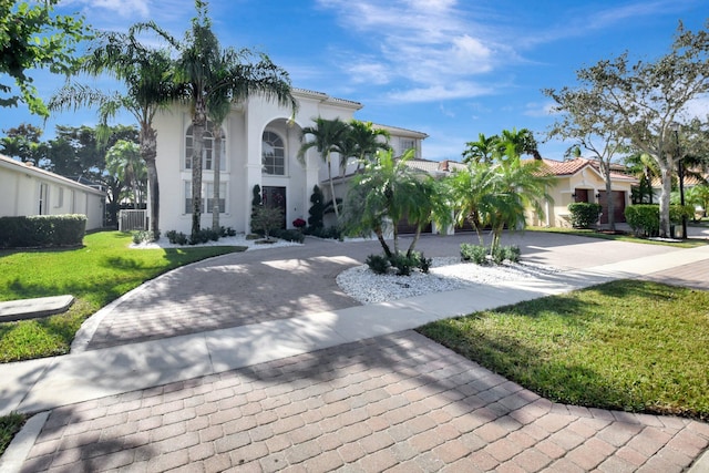 mediterranean / spanish-style home featuring cooling unit and a front yard