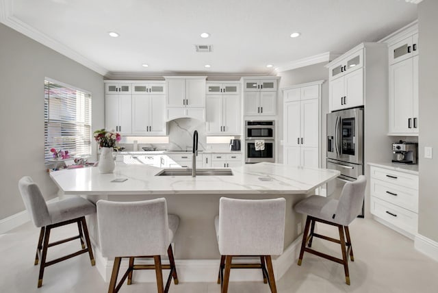 kitchen featuring a kitchen bar, white cabinetry, sink, and appliances with stainless steel finishes