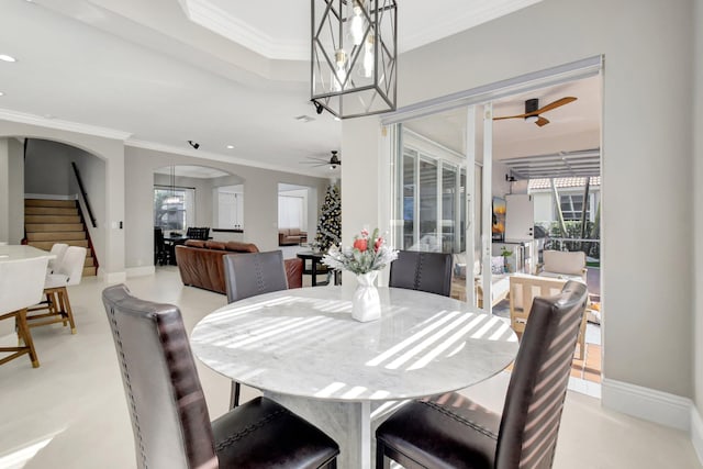 dining area with ceiling fan and crown molding