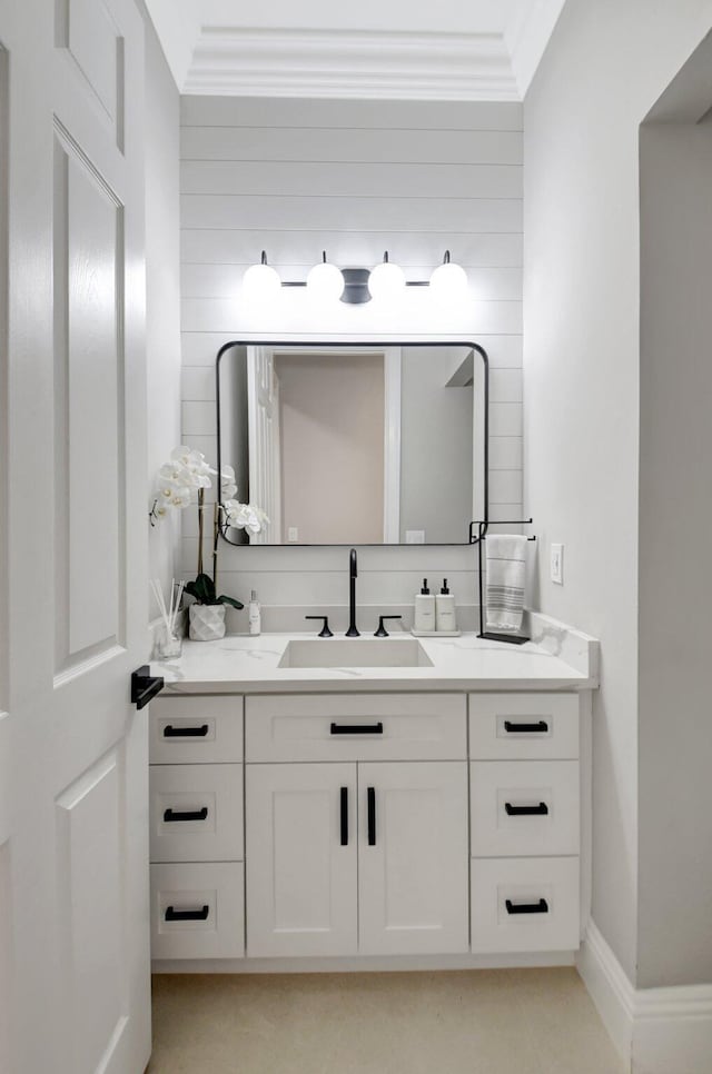 bathroom with vanity, wood walls, and crown molding