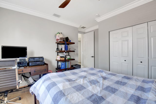 bedroom with hardwood / wood-style floors, a closet, crown molding, and ceiling fan