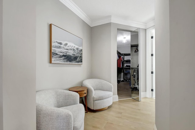 sitting room with hardwood / wood-style floors and ornamental molding