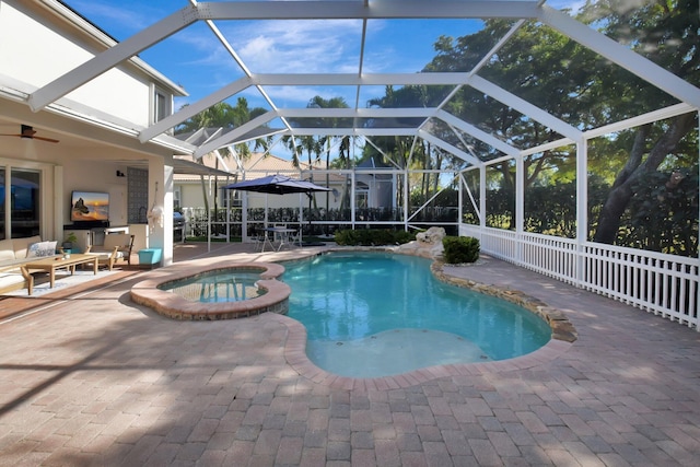 view of pool featuring an in ground hot tub, glass enclosure, and a patio area